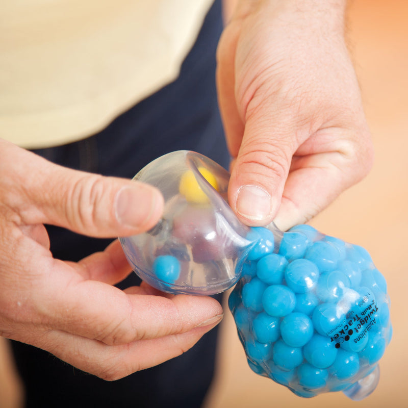 twidget tracker ball, van timove, blauwe zandloper bal in handen van een senior, bejaarde, oefenmateriaal