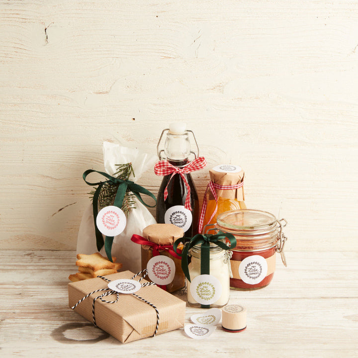 voorbeeld om cadeautjes te versieren met de stempels uit de adventskalender zelf ingemaakte producten met labels, op houten achtergrond