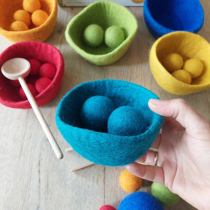 vilten bakje vilten bolletjes in verschillende kleuren en maten met hand als reverentie, goki, farbsortierspiel