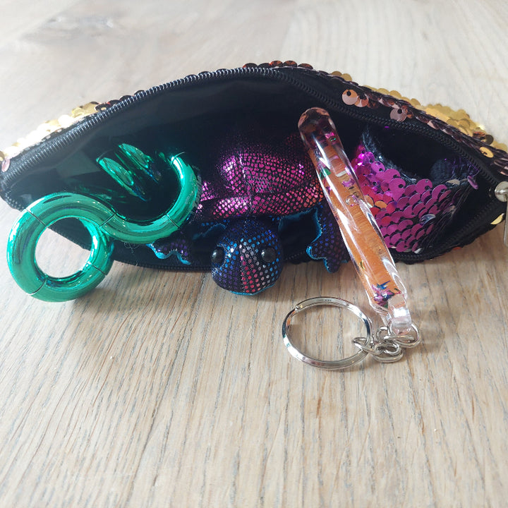 details van het fidget etui: mini zanddier, toverstaf sleutelhanger, tangle, klaparmband, figet speelgoed