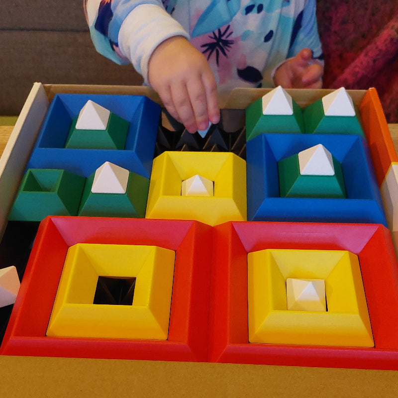 peuter speelt met piramiden puzzel, fijne motoriek speelgoed, Kind speelt met Triangle Puzzle constructiespeelgoed