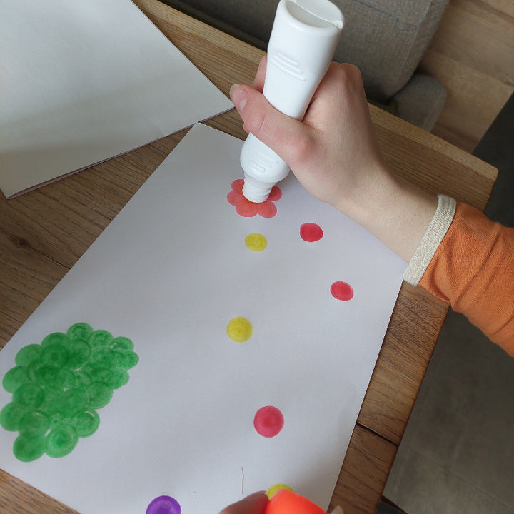 Kind maakt stippenkunst met ergonomische tupferstiften