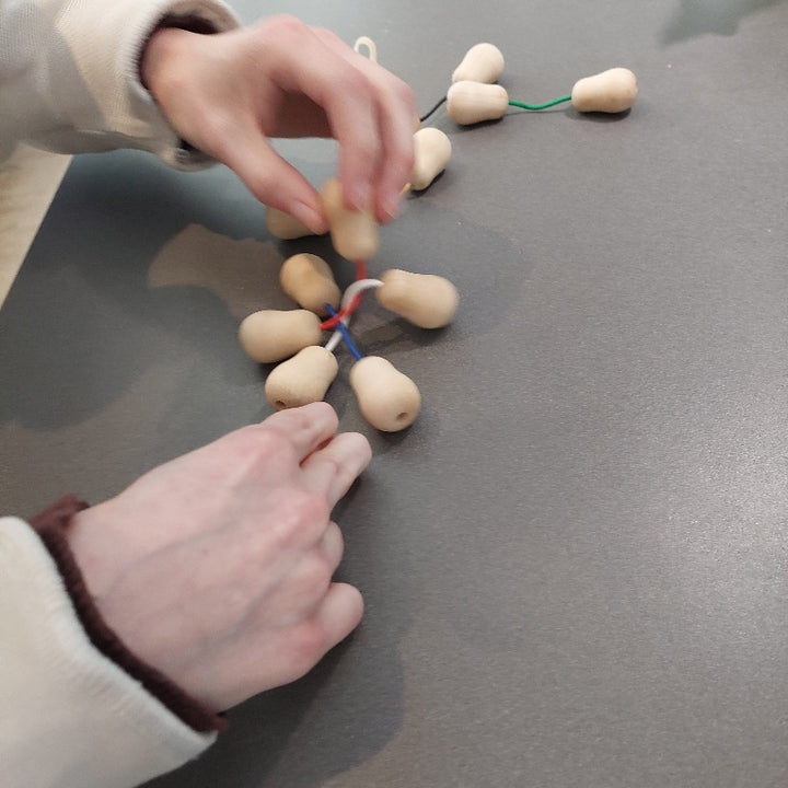 tweehandig spelen met de toverknoop geduldsspel, in elkaar en uit elkaar draaien