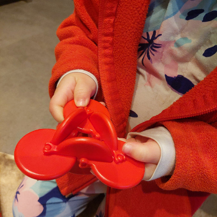kind, 3 jaar, met osm in rood in de handen, kinderspeelgoed, fidget