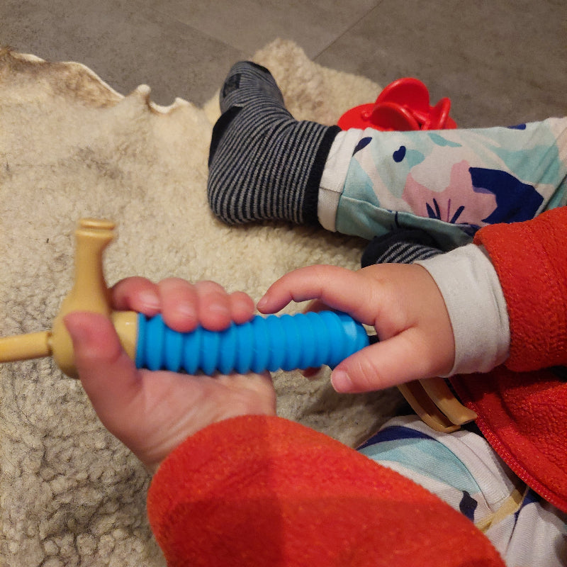 blauwe pop tube hond in kinderhanden, fidget dog
