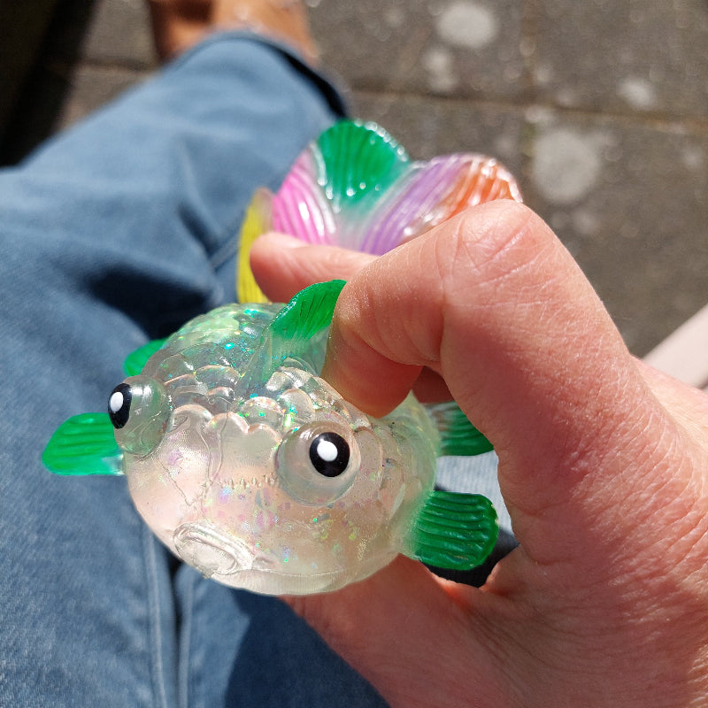 maltose squeeze fidget goudvis in hand, zonschijn