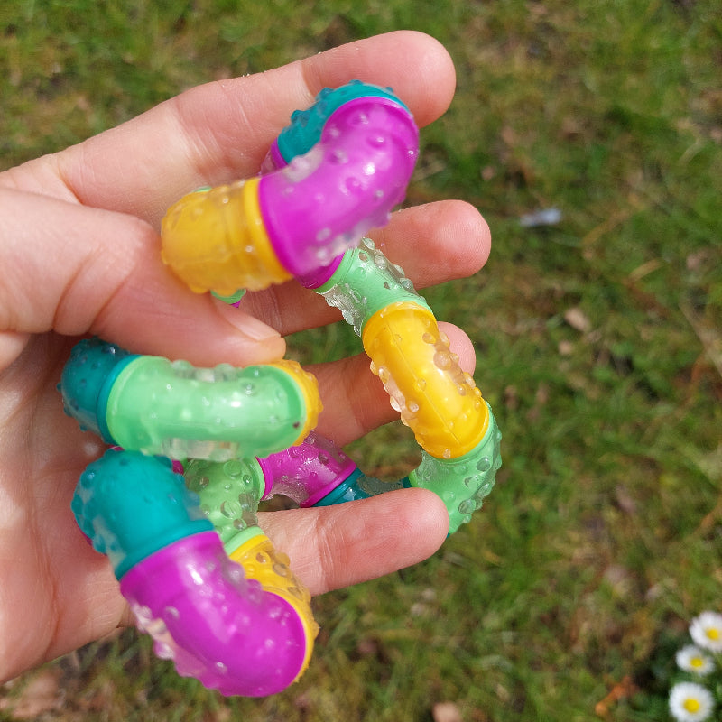 tangle think, grote therapy tangle met rubber laag, in hand achtergrond gras