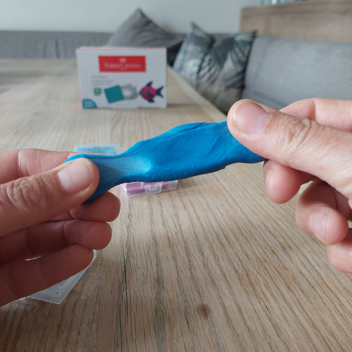 Handen trekken aan de kneedgum, waardoor de flexibele structuur van het art eraser materiaal zichtbaar wordt