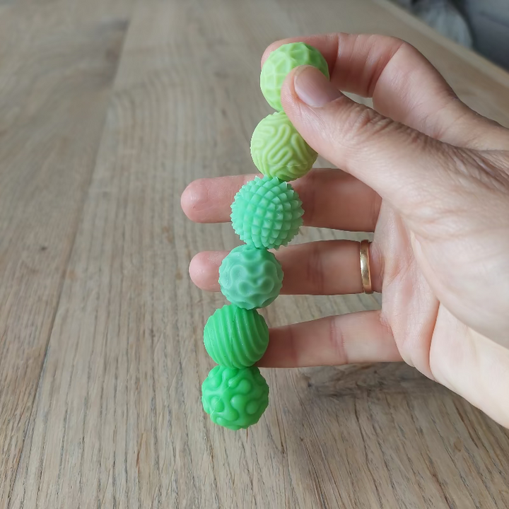 hand houd 6 fidget magneetballen. Glow in the dark fidget fidgnetic magneetballen, sensoriek materiaal