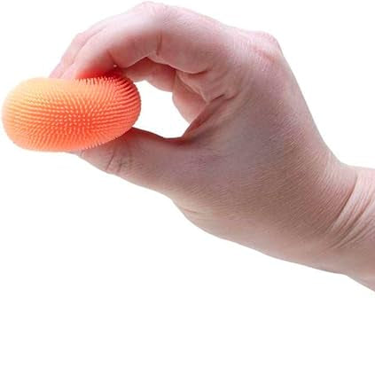 Hand die een zachte NeeDoh Teenie Fuzz Ball vasthoudt en indrukt met velvet squeeze textuur


