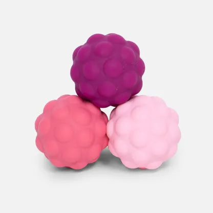 Drie SPEKS Odds roze silicone fidget ballen met grote noppen los zonder verpakking, duidelijk zichtbaar op tafel