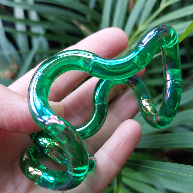Tangle gem groen verdreht auf einer Hand vor Blättern