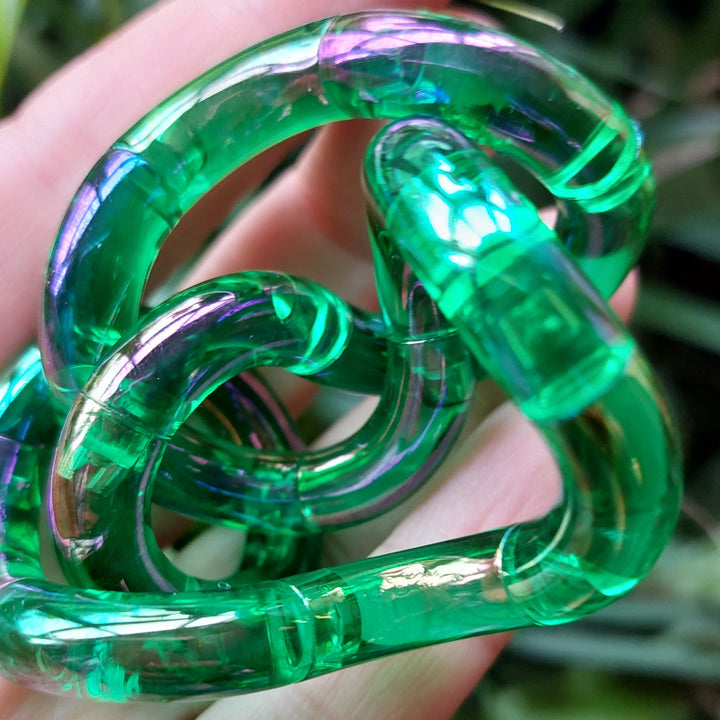 Tangle gem groen gedraaid op hand voor groene achtergrond