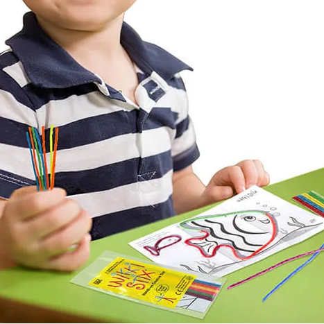 kind met wikki stix en werkblad uit het kleine proefsetje of uitdeelzakje, fijne motoriek speelgoed