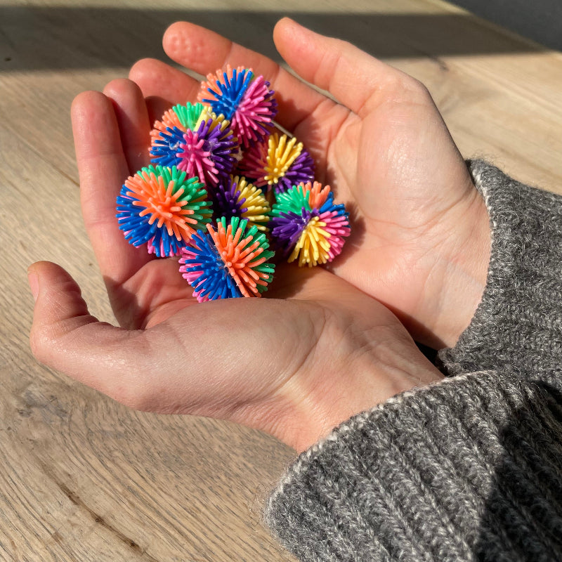 Stekelige mini regenboogballen in handen