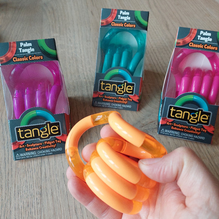 Palm tangle oranje in hand, op de achtergrond andere kleuren palm tangles