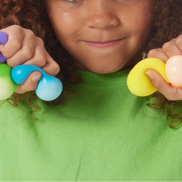 regenboog needoh, kind met teenie ballen in beide handen, gedrukte zacht antistress ballen