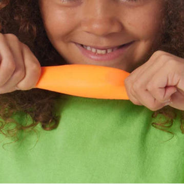 regenboog needoh teenie 6 stuks, kind heeft een orangje bal in twee handen vast en trekt er aan