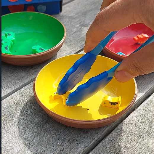 pincet met mini gummetje dino, gele dino in gele kom met blauwe pincet, kinderspeelgoed