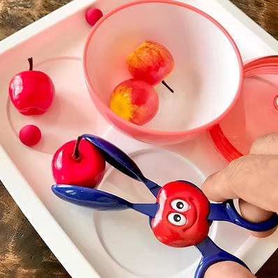 kinderhand met speelgoed schaar, appel tong