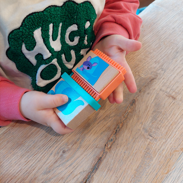 steekpuzzel met dieren, noppenblokken, motoriekspeelgoed, kind met twee blokken in twee handen