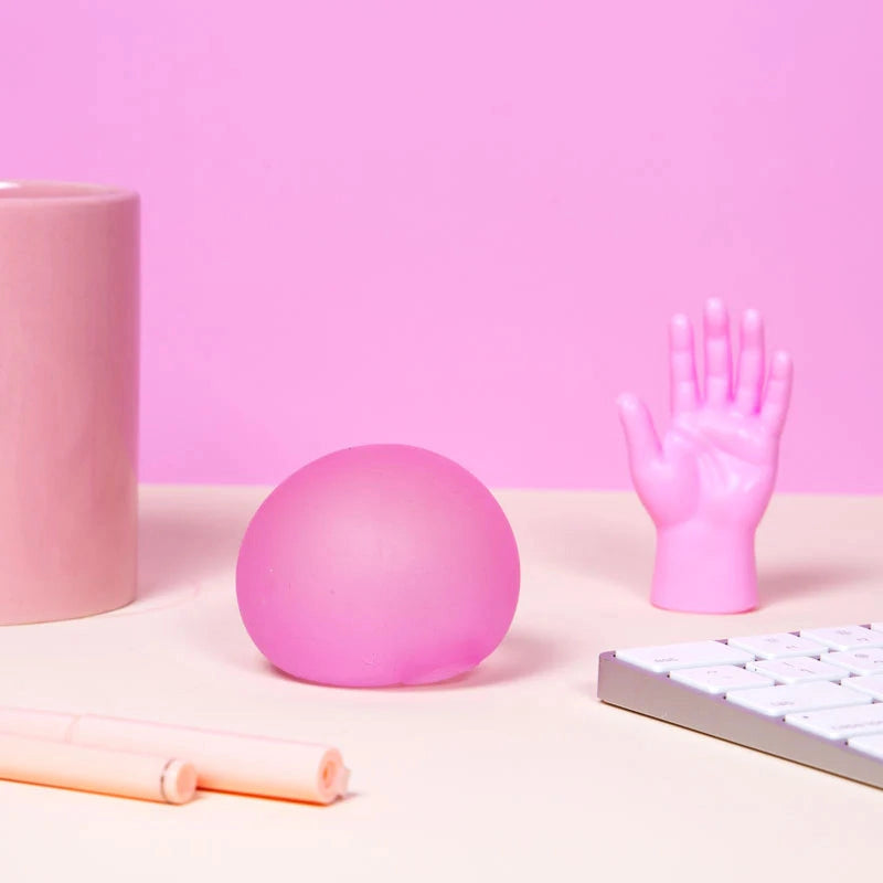 roze speks antistressbal met roze pen en keyboard op tafel