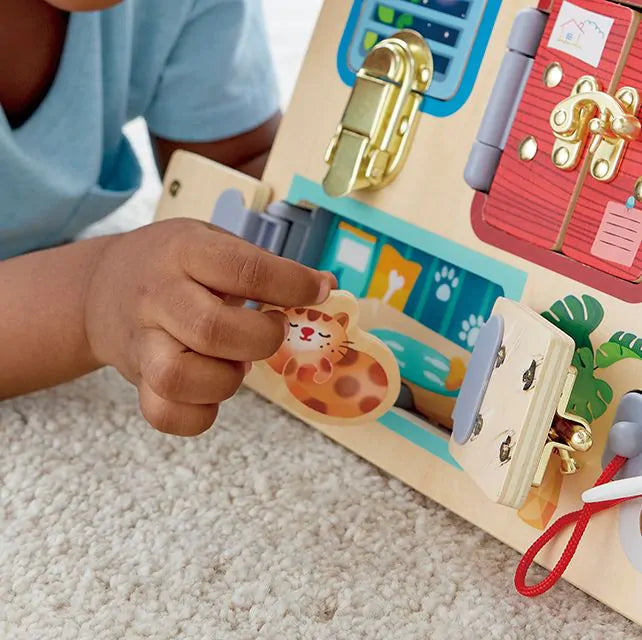 Close-up van een kinderhand die een slot of sluiting bedient op het Lock & Learn Playboard