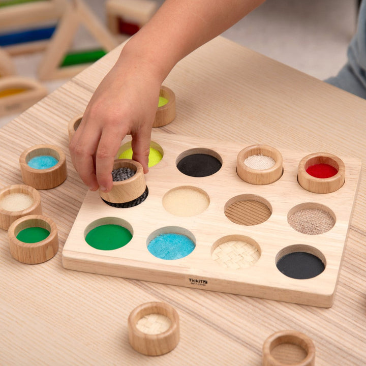 kind aan het spelen met tickit voel en match bord, sensoriek spel