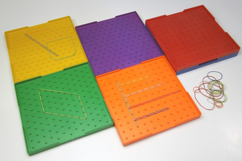 Zes grote geoboards met verschillende elastiek patronen naast elkaar voor meetkunde onderwijs