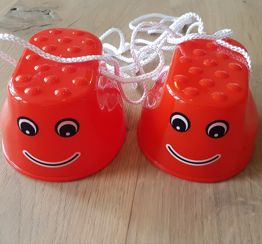 JToys Loopklosjes, kleine rode loopklossen met smily, gezichtje op houte tafel 