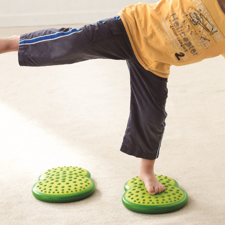 weplay Balance clouds, kind op blote voeten balanceerd op een groene balance cloud, motoriekspeelgoed, grove motoriek evenwicht