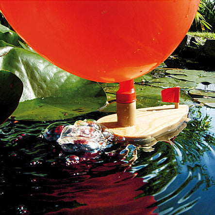 Houten ballonbootje in water met opgeblazen ballon en zeerpzem