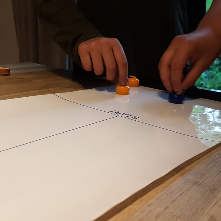 kikkerland Tafel curling, twee handen bij de start van het spel