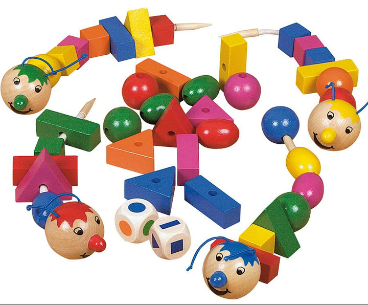 Losse houten vormen, rupsfiguren en dobbelstenen van het spel Rondo Vario overzichtelijk uitgestald