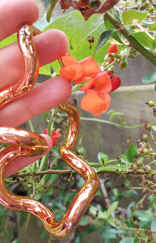Tangle Metallic tangle oranje voor oranje bloem in hand