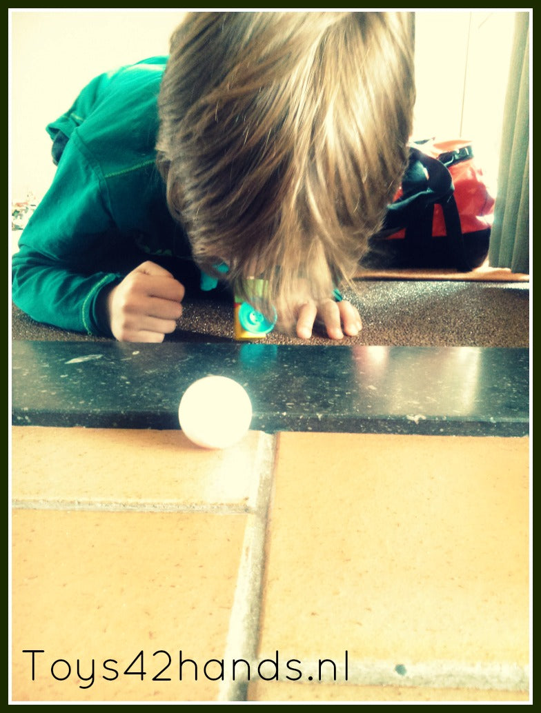 Kind blaast piepschuim bal over de grond met blaas locomotief