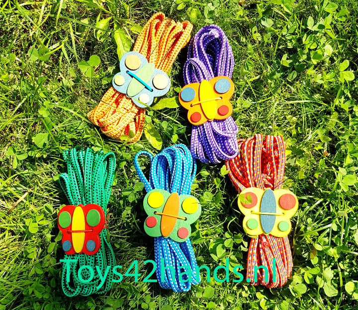 Legler Springelastiek, buitenspeelgoed, spring elastiekjes in 5 kleuren in gras met houten vlinder