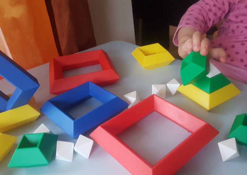 Kind speelt met Triangle Puzzle constructiespeelgoed, bouwen met inzicht en fantasie