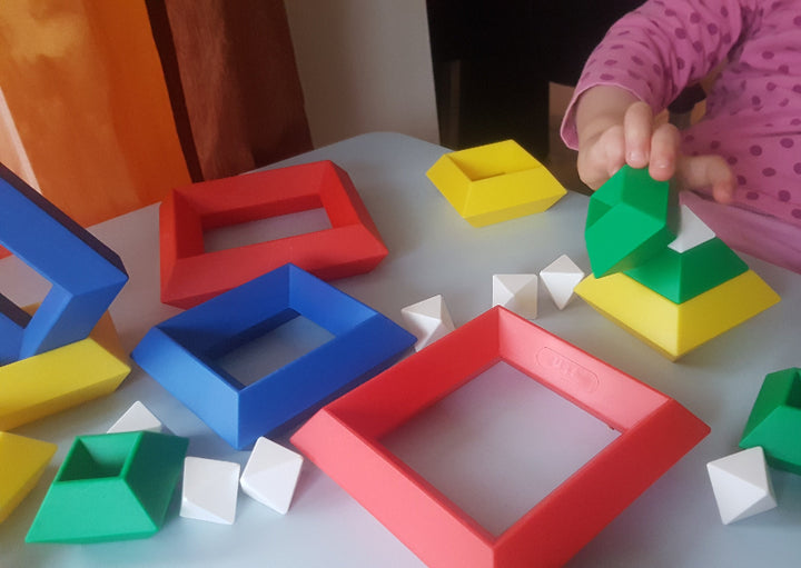 Kind speelt met Triangle Puzzle constructiespeelgoed, bouwen met inzicht en fantasie