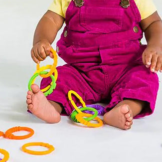 Baby speelt met kleurrijke speelringen van Bright Starts Lots of Links