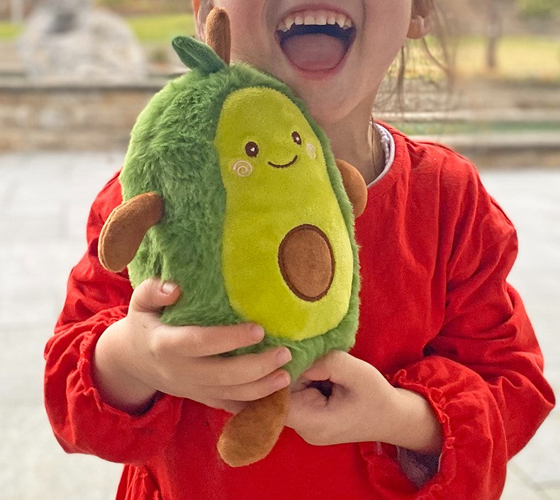 knuffelrecorder, napraat knuffel in de vorm van een avocado. Kind met rood shirt heeft de avocado lachend in de hand